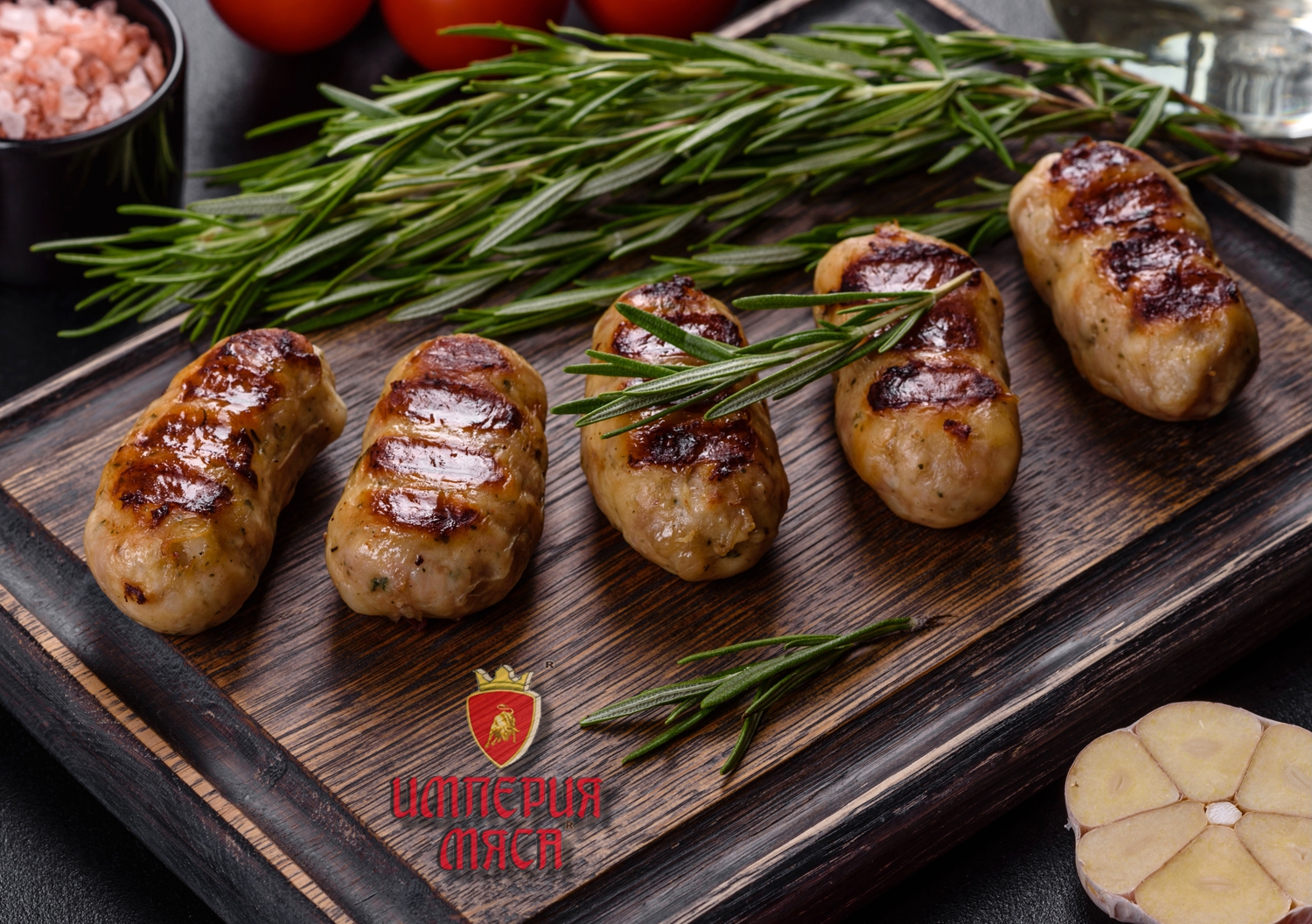 Grilled sausage with the addition of herbs and vegetables on the dark background