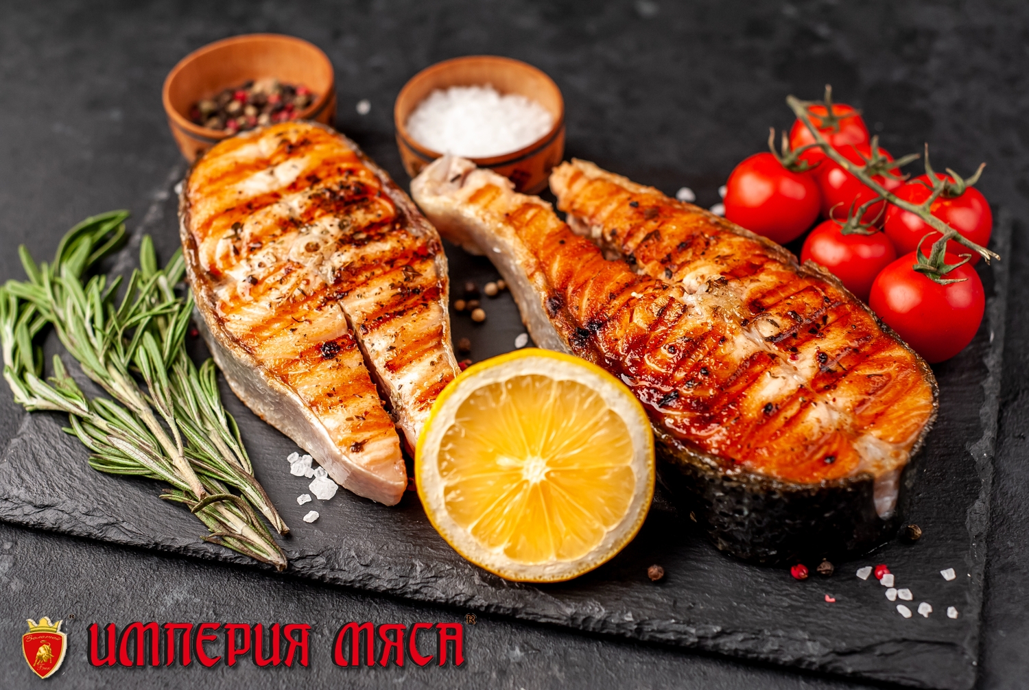 Grilled salmon steak with lemon and rosemary on a stone backgrou